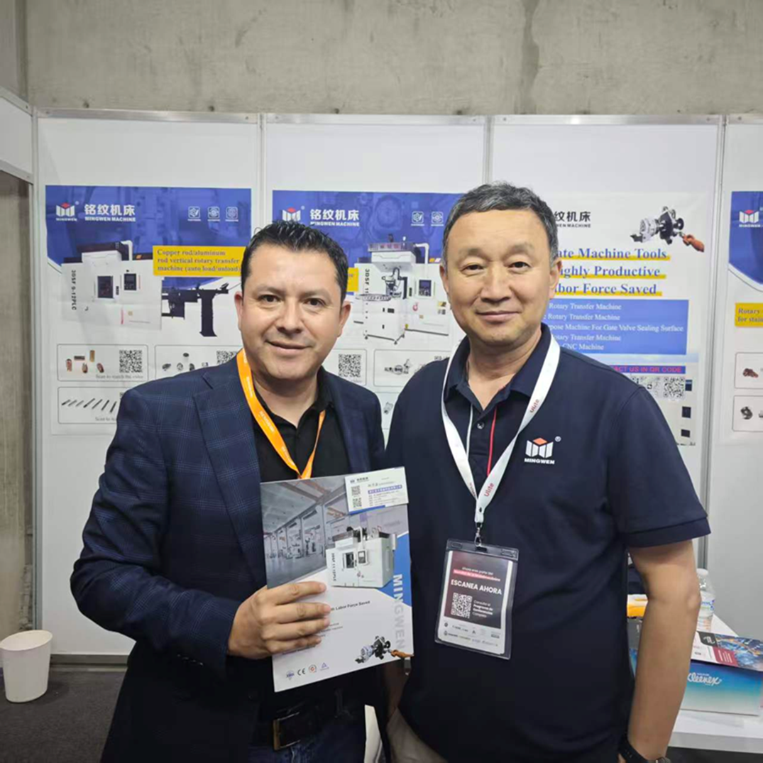 标题: Mexican manufacturing visitor and Qingdao C&C representative discussing a rotary transfer machine brochure at EXPOMAQ 20 - 说明 Mexican manufacturing visitor and Qingdao C&C representative discussing a rotary transfer machine brochure at EXPOMAQ 2026